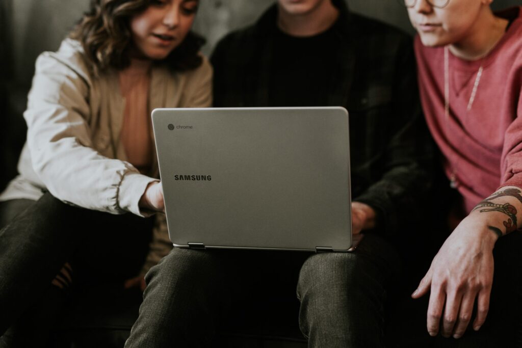 Young workers pointing at a laptop, perhaps exploring the idea of a job in solar.
