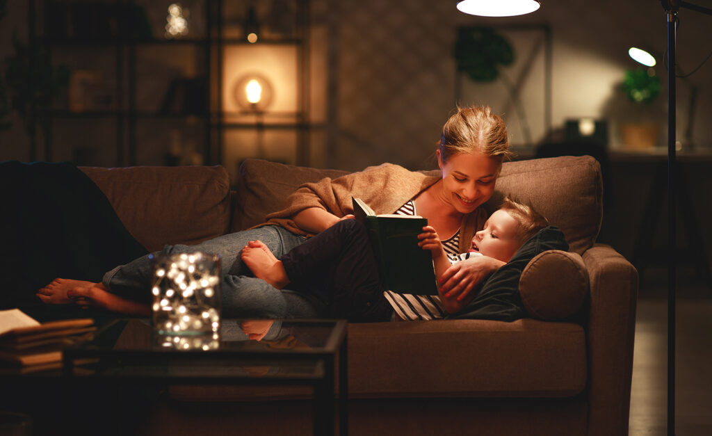 A mother and daughter reading on the sofa, enjoying their solar lights.
