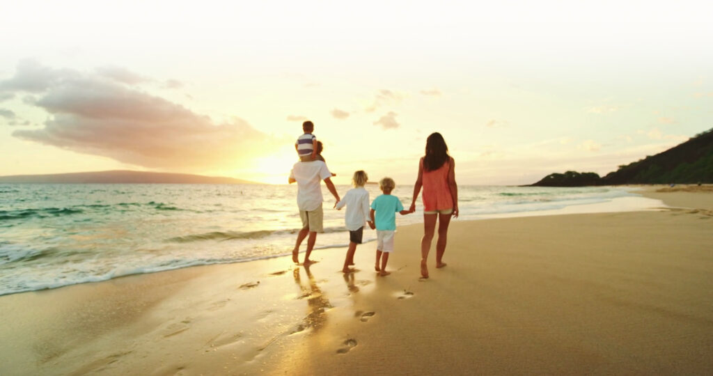 A family on a beach walking towards the sun and a brighter, more sustainable future with solar panels in Ireland.