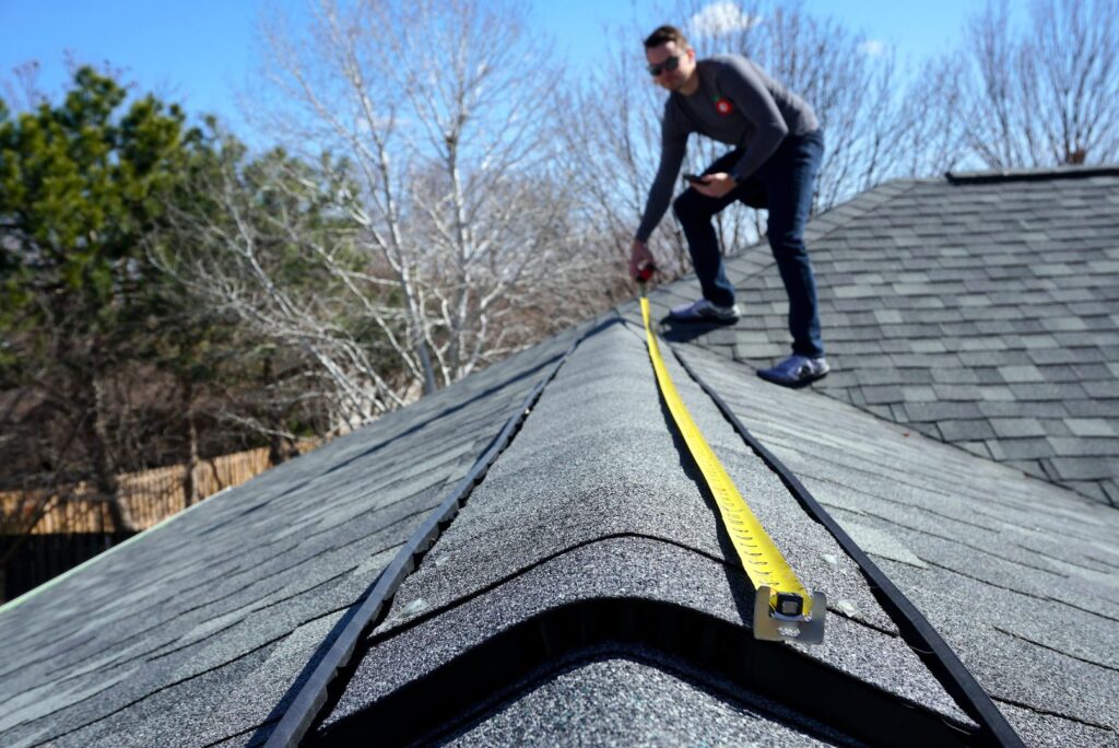 A man measuring a roof so he knows how many solar panels he can fit on it for planning permission. Planning permission for solar panels is no longer needed in Ireland