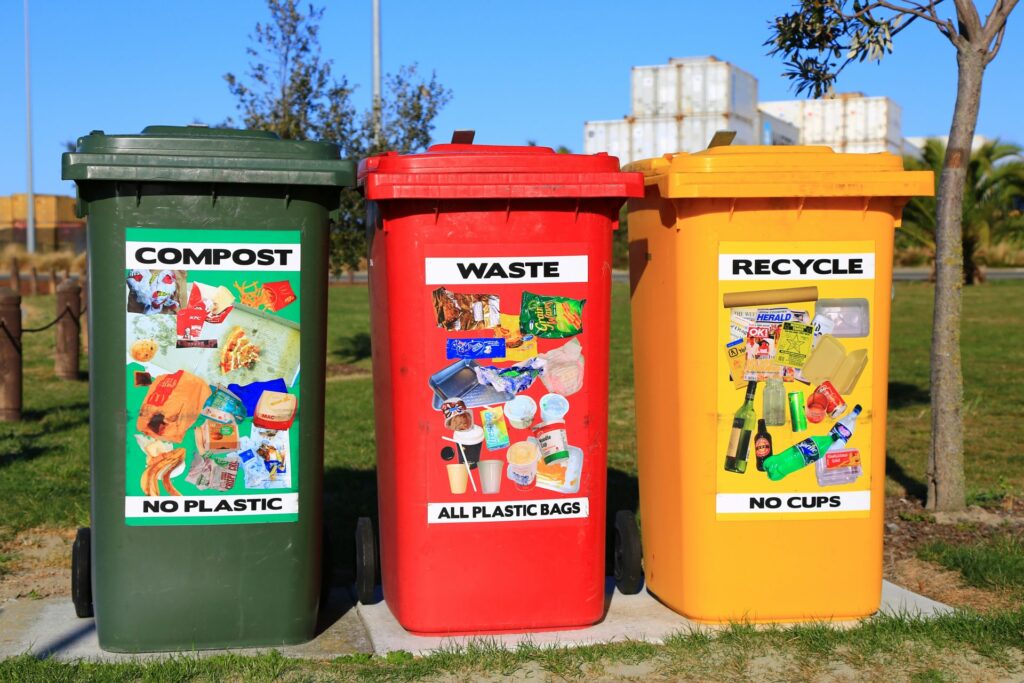 3 wheelie bins with clear signs telling you how should waste be recycled and disposed of. In the same way, solar panel waste should be disposed of properly so that it can be recycled and reused in the future for a more circular, greener economy.