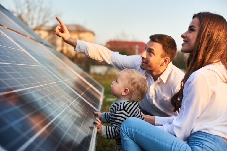 A woman in solar with her family looking at a solar panel.